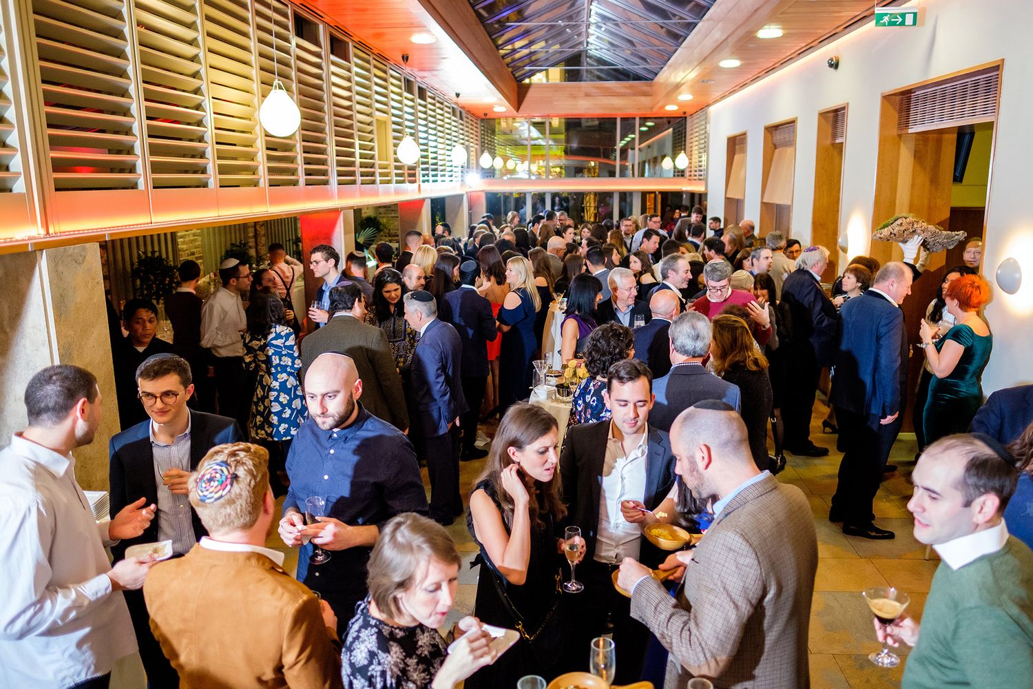 Large group of people gathered in a brightly lit hall for a professional networking event.