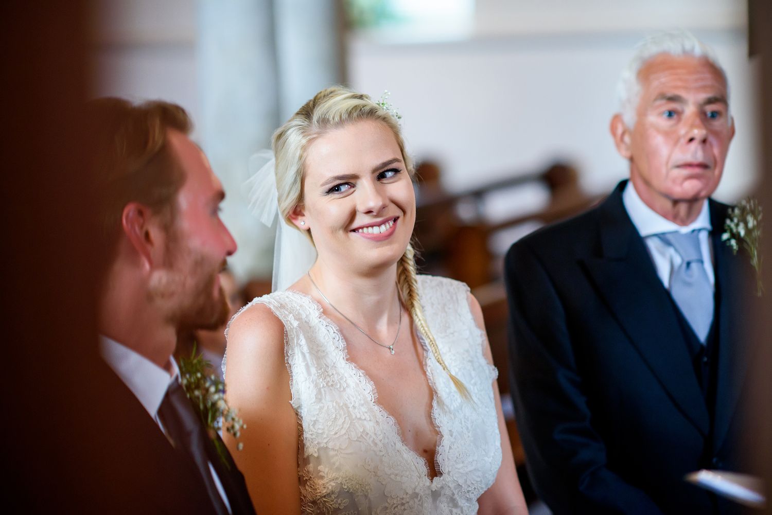 Wedding ceremony participants looking at paperwork in a formal church setting.