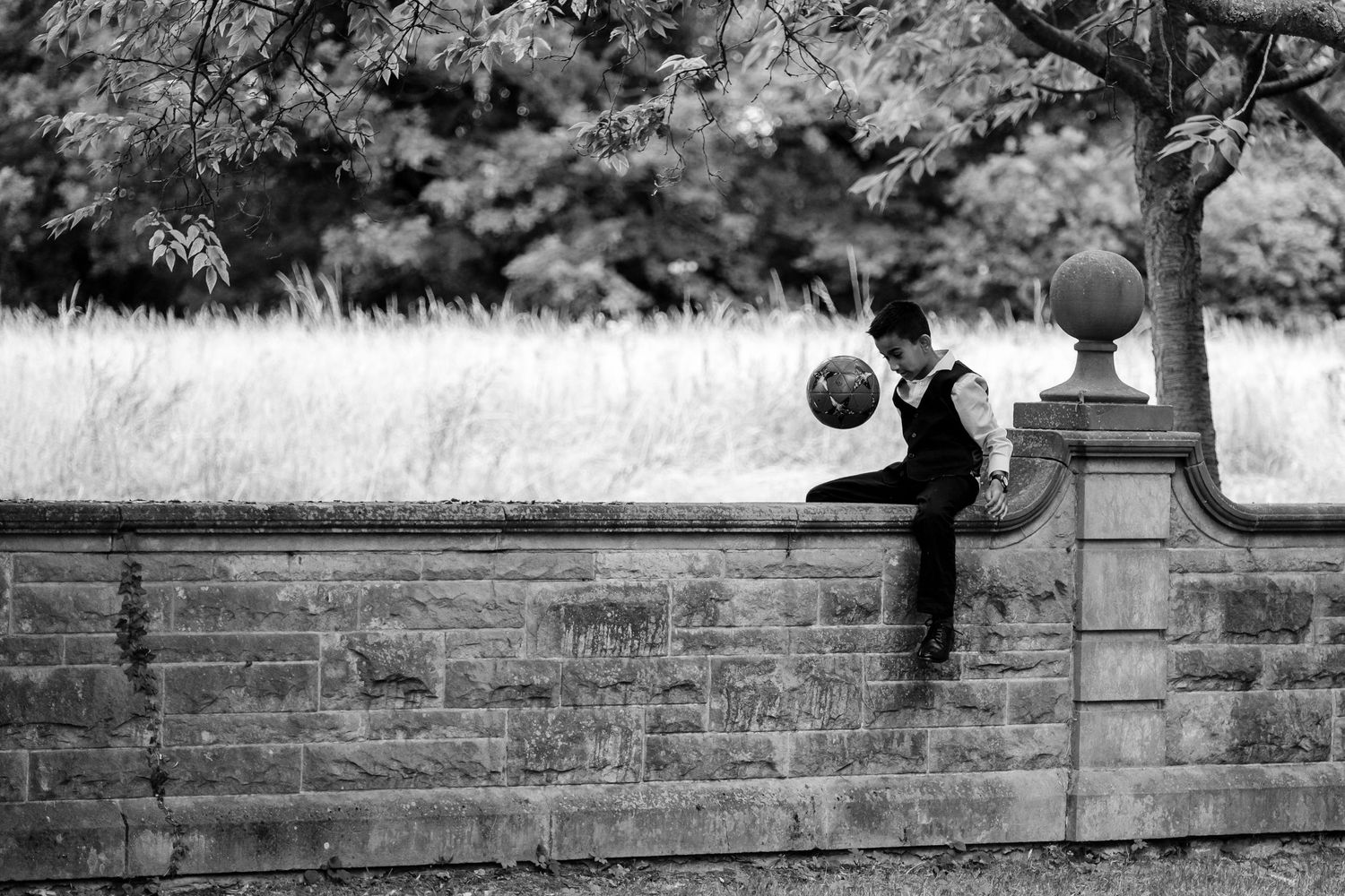 Black and white artistic silhouettes taken along a stone wall outdoors.