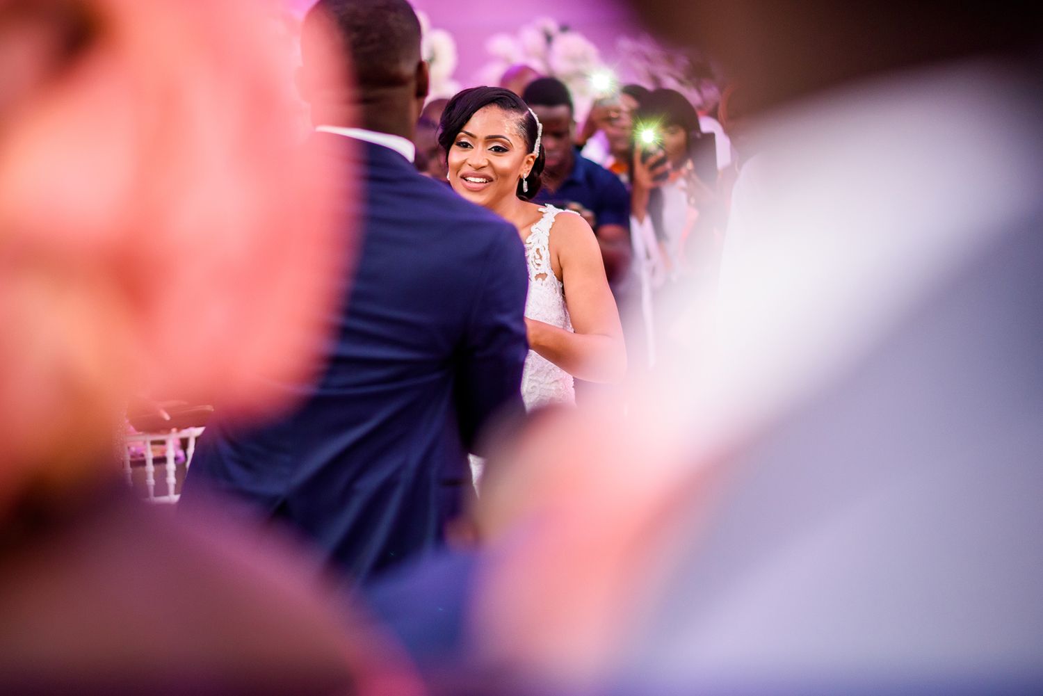 Elegant wedding reception with soft focus pink and purple lighting effects.