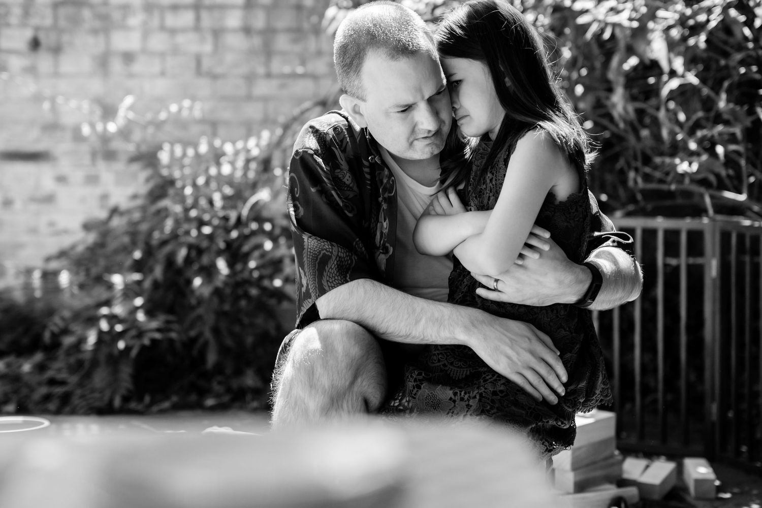A series of black and white romantic engagement photos showing intimate moments between a couple in an outdoor setting.