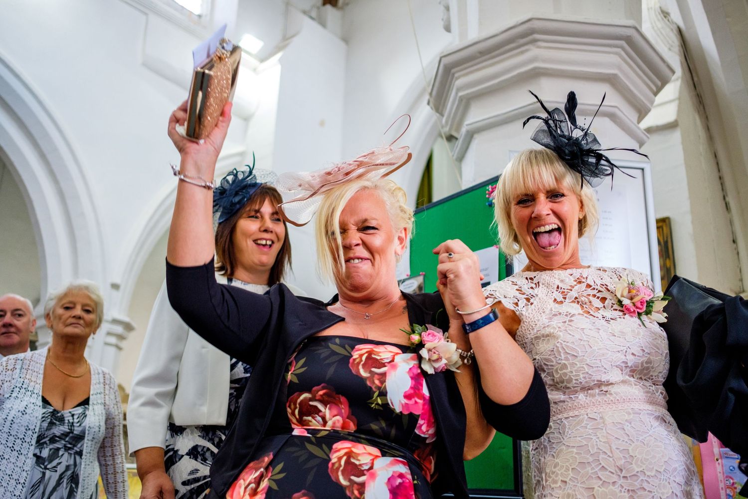 Wedding reception guests dancing and celebrating with joyful expressions in an indoor venue.