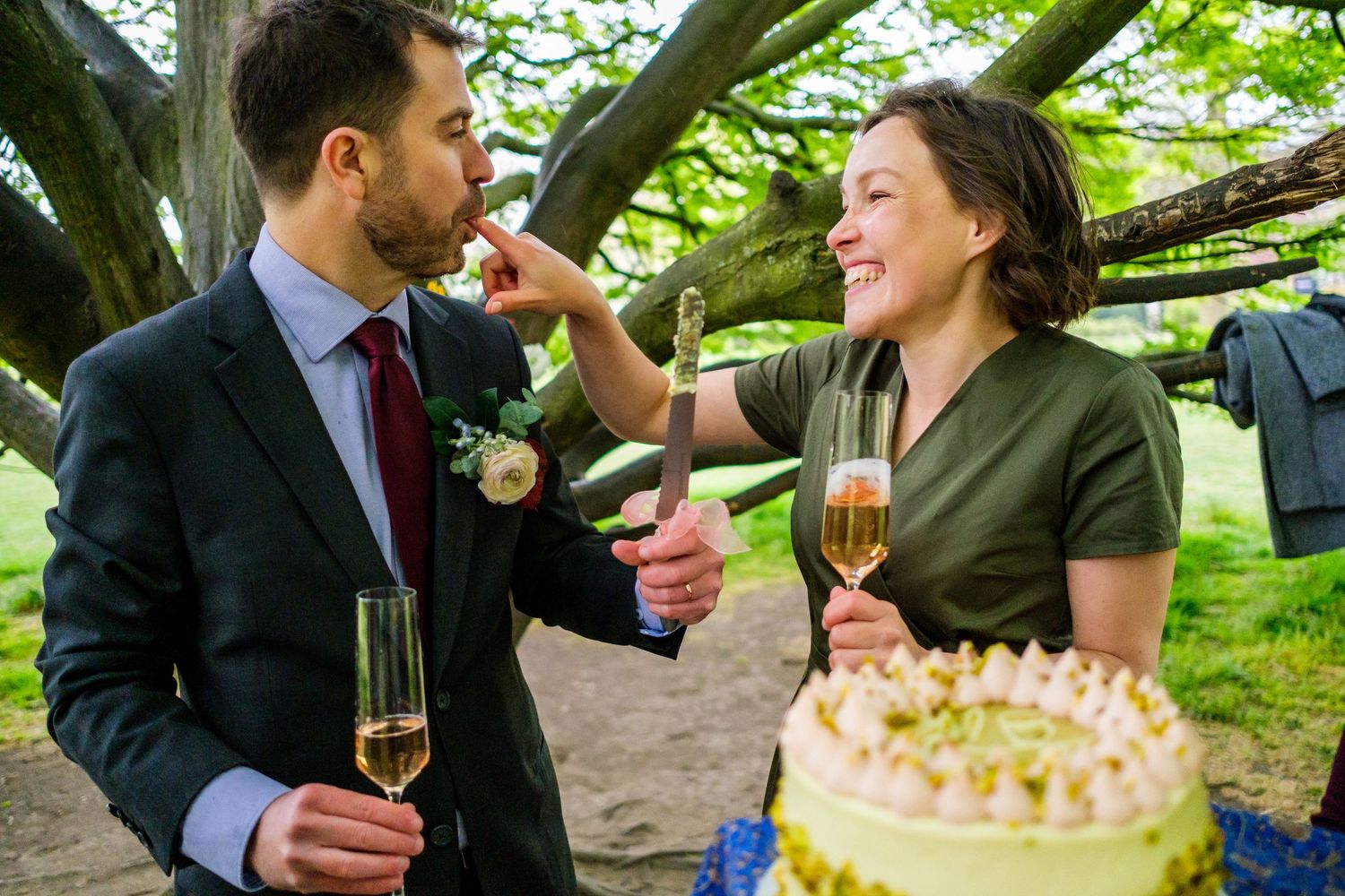 Group enjoying champagne and appetizers at an outdoor celebration under green trees.
