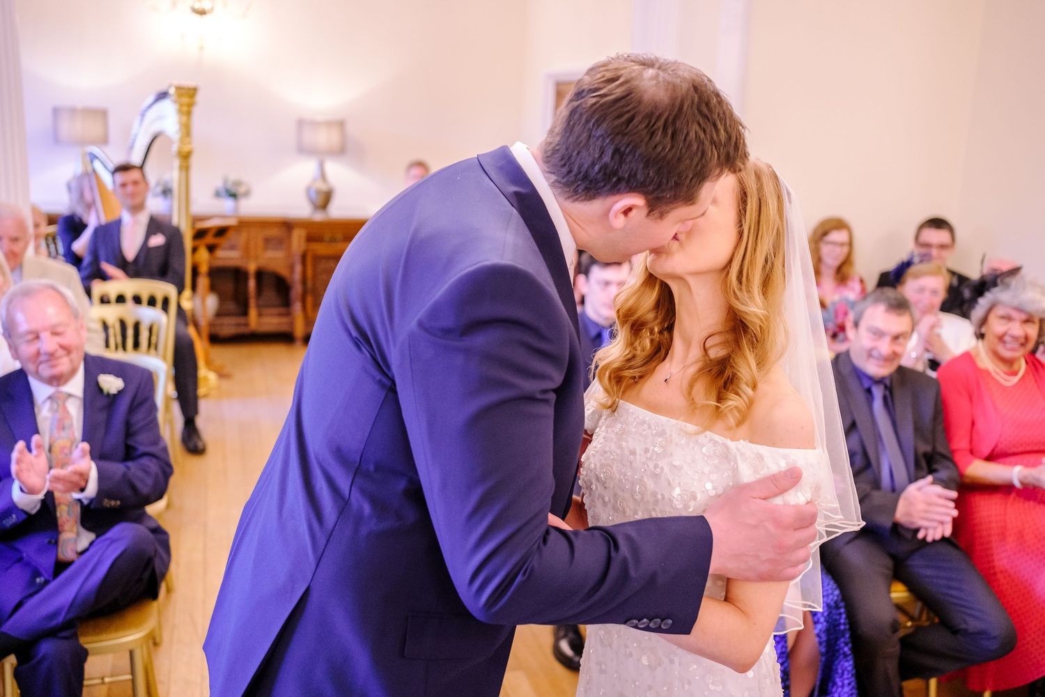Wedding guests watching a couple's first dance in an elegant indoor venue.