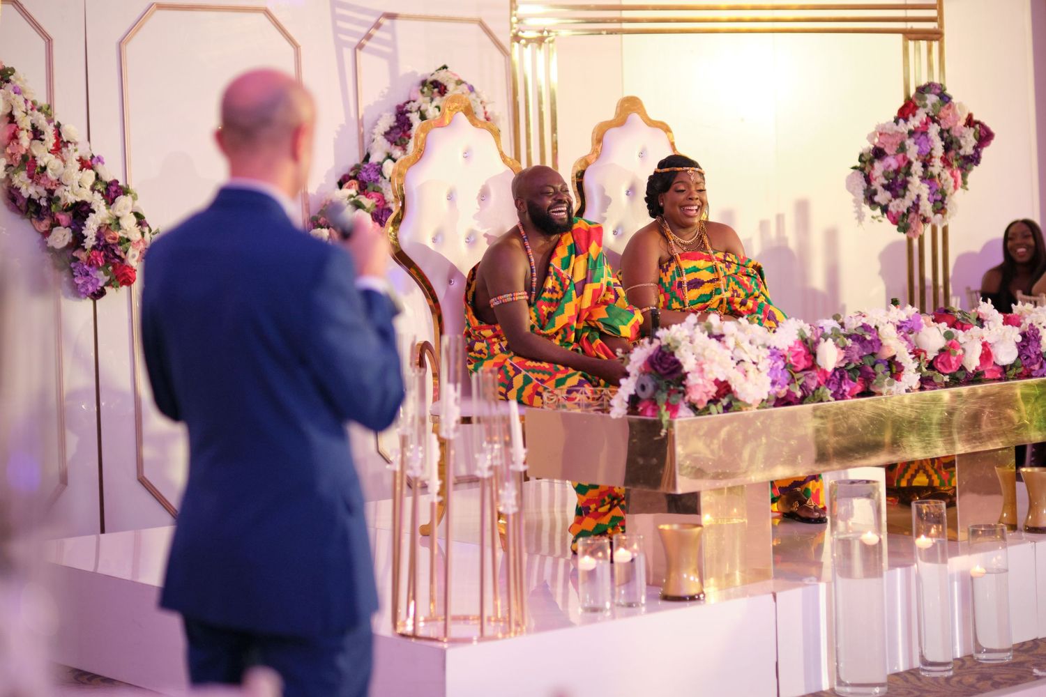 Elegant wedding reception venue with white decor, floral arrangements, and gold accents.