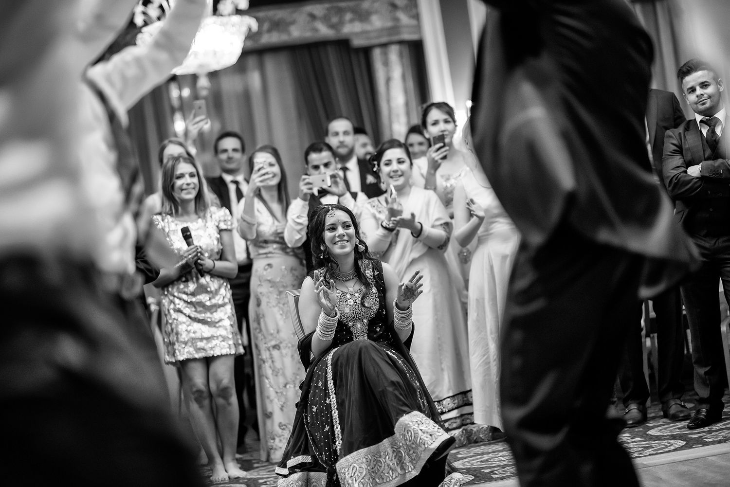 Wedding guests celebrate joyfully on the dance floor at a reception.
