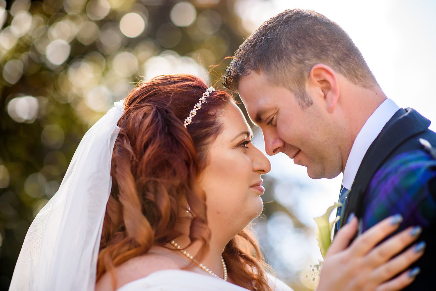Romantic moment captured between newlyweds in soft natural lighting.