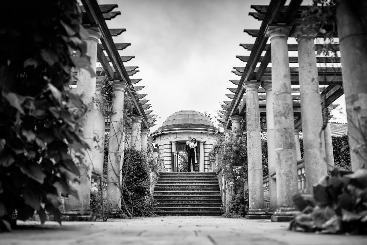 Black and white landscape of stone stairs and columns in a symmetrical garden setting.