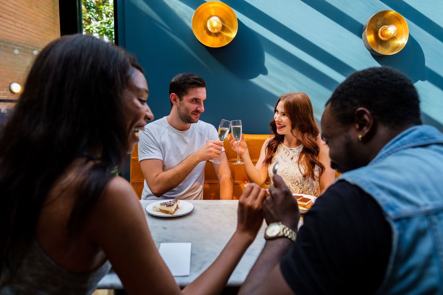 Diverse group of customers dining and socializing at restaurant tables.