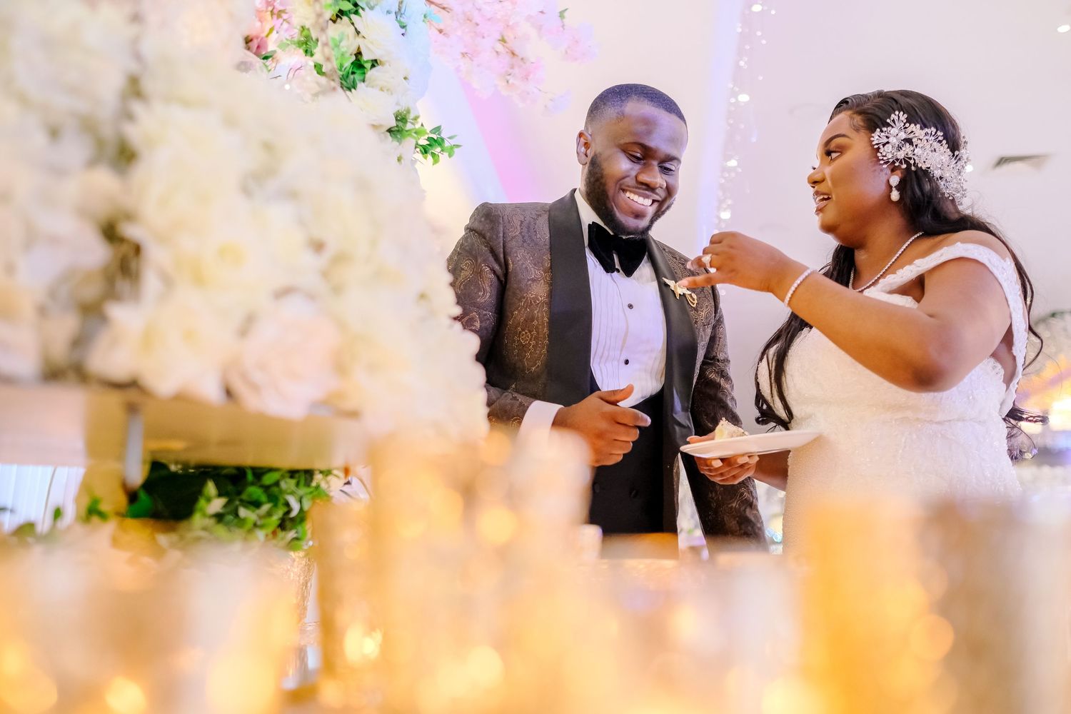 Romantic moment shared between newlyweds at their reception with soft lighting and floral decor.