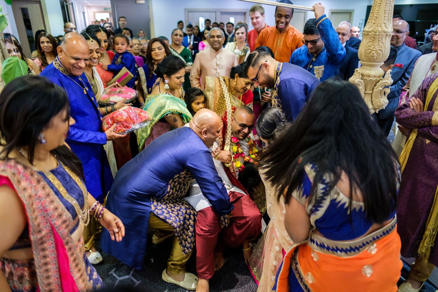 Guests mingling and socializing at a vibrant Indian wedding celebration with colorful traditional outfits.