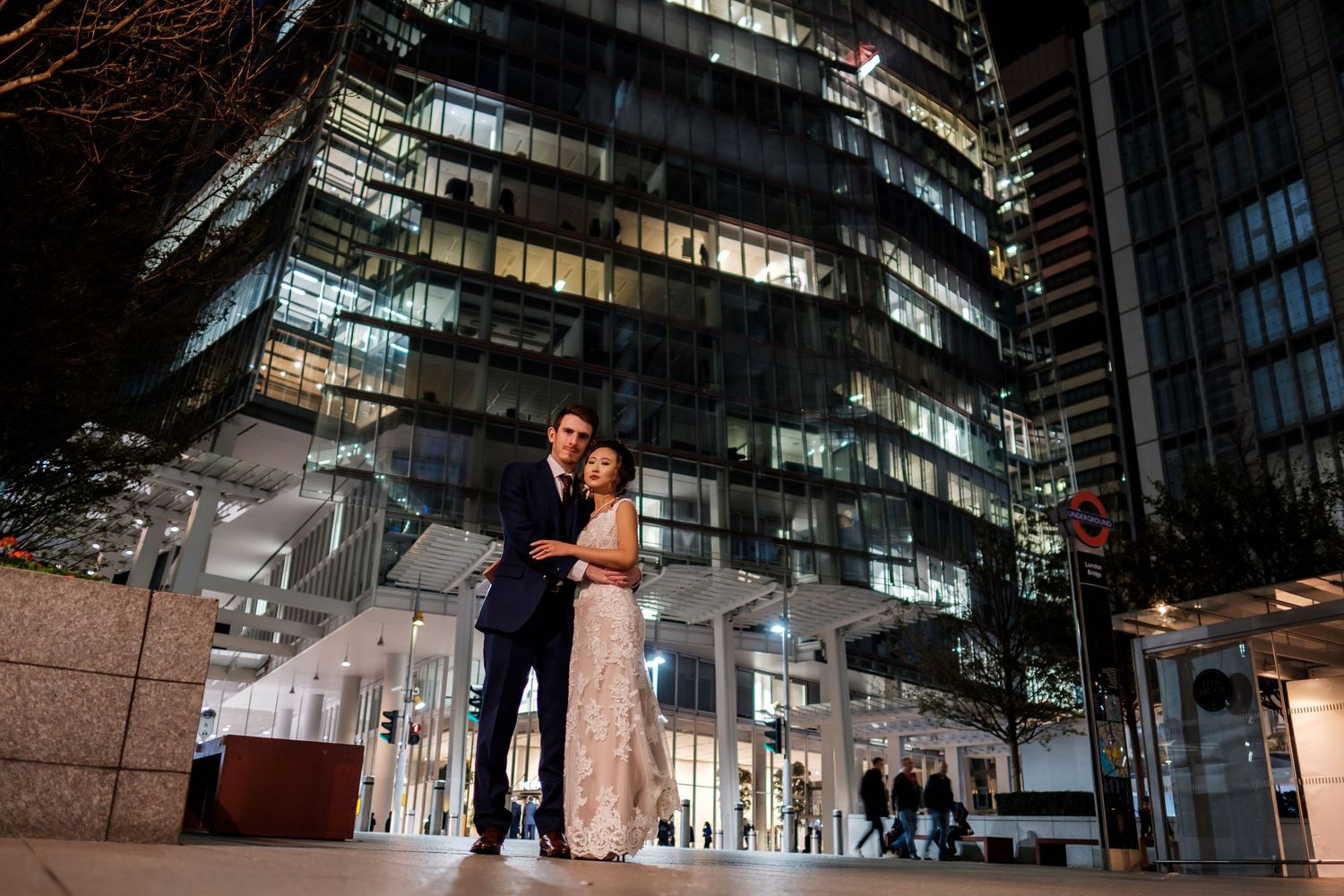 A couple dances together during their first dance at a modern venue with illuminated stairs in the background.