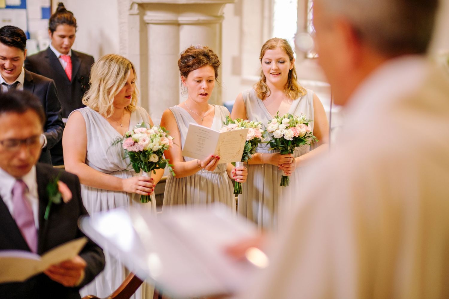Wedding party members raise champagne glasses in a toast during an elegant reception celebration.