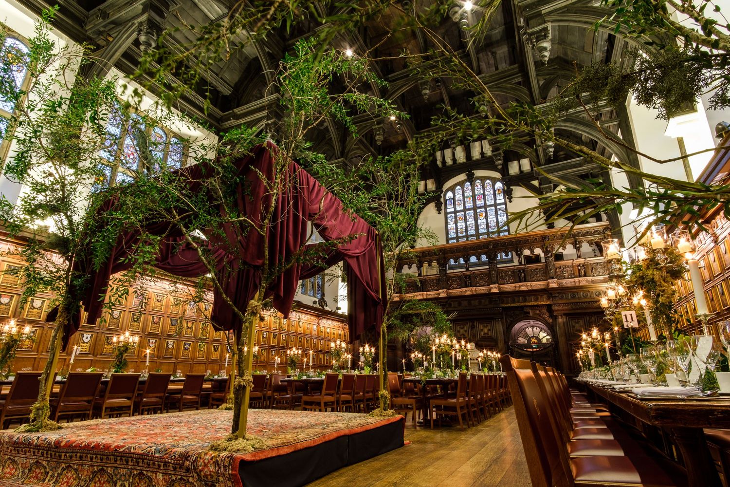 Elegant restaurant interior with hanging plants and Gothic architectural details.