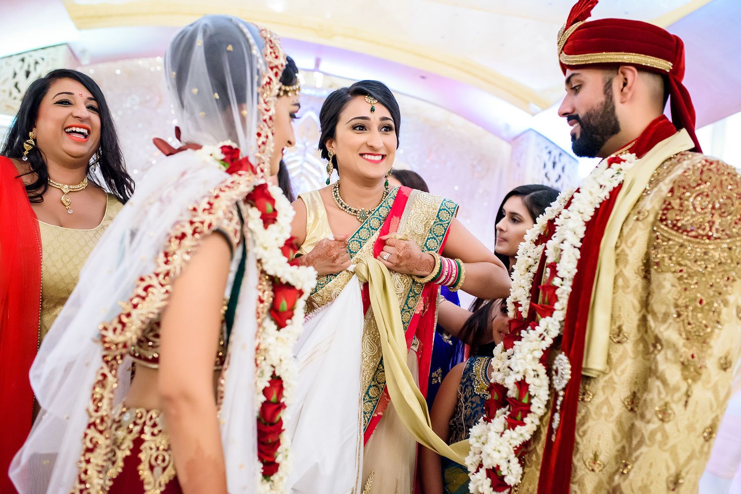 Festive celebration at an Indian wedding with guests in vibrant saris and traditional outfits.