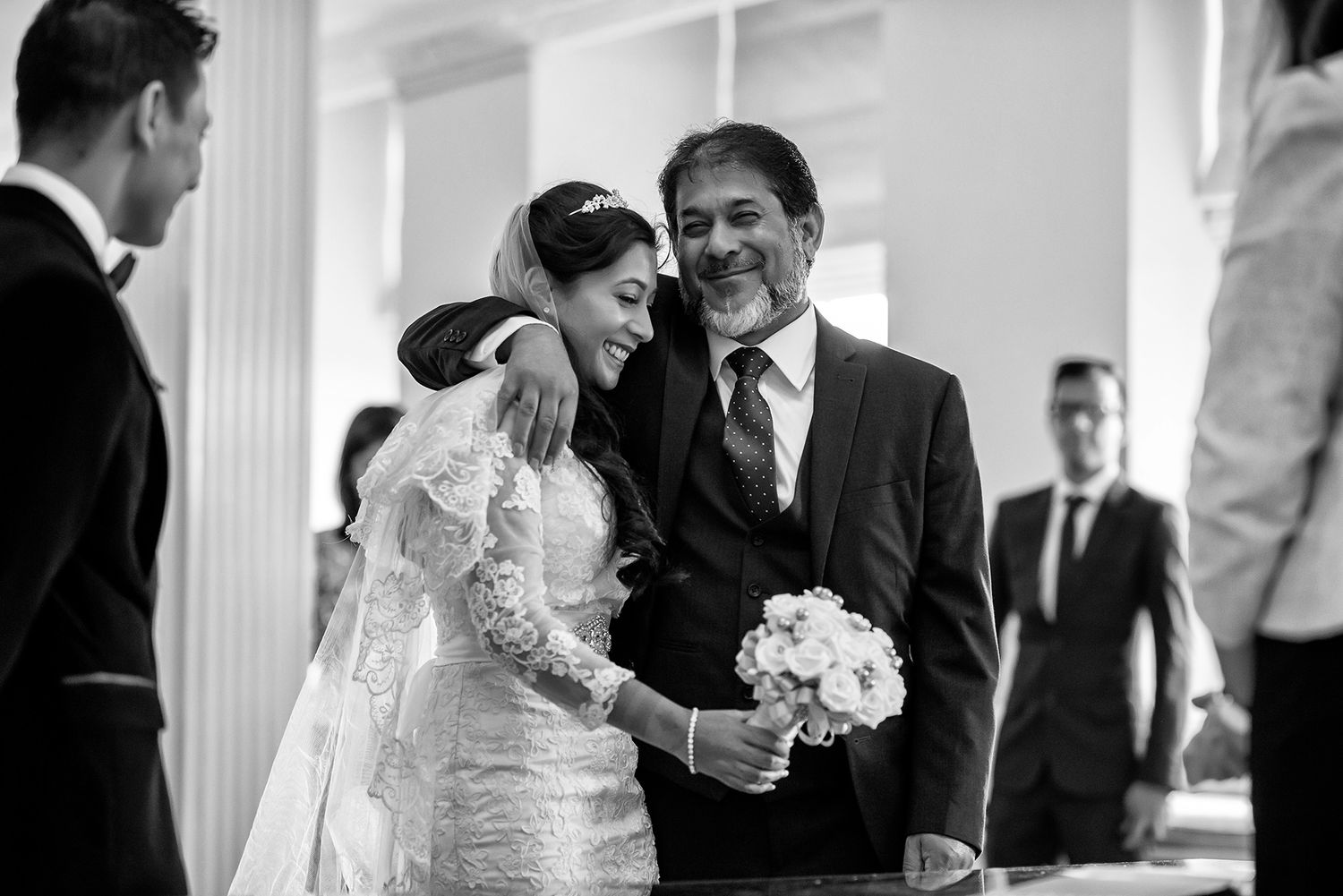 Elegant wedding ceremony taking place in a bright white interior space.