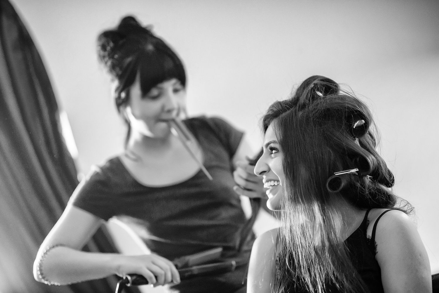 Black and white photo showing wedding day preparation activities in a cozy room.