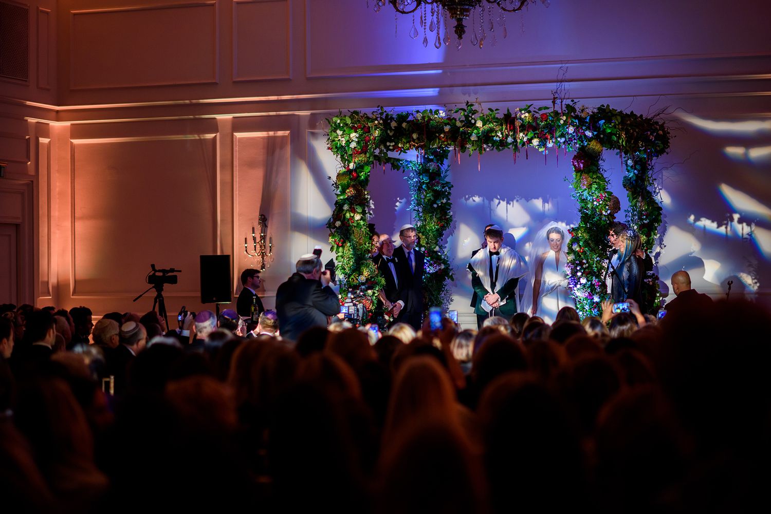 Wedding ceremony space with floral decor and dramatic lighting creating an ethereal atmosphere.