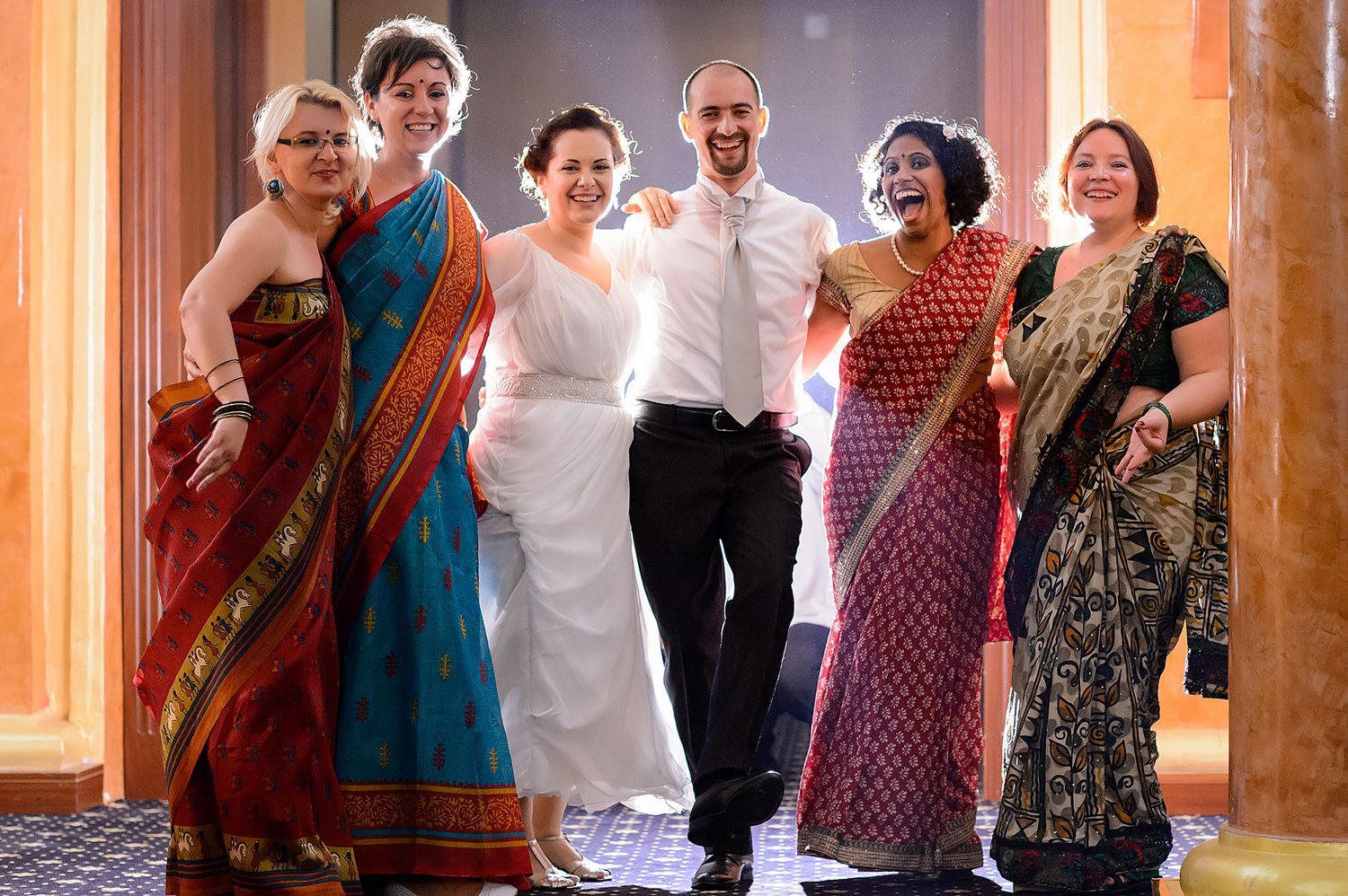 Wedding celebration with guests wearing colorful traditional saris and formal attire.