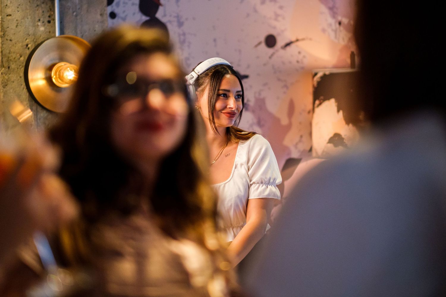 People socializing at a dimly lit bar or restaurant, creating a warm and cozy evening atmosphere.