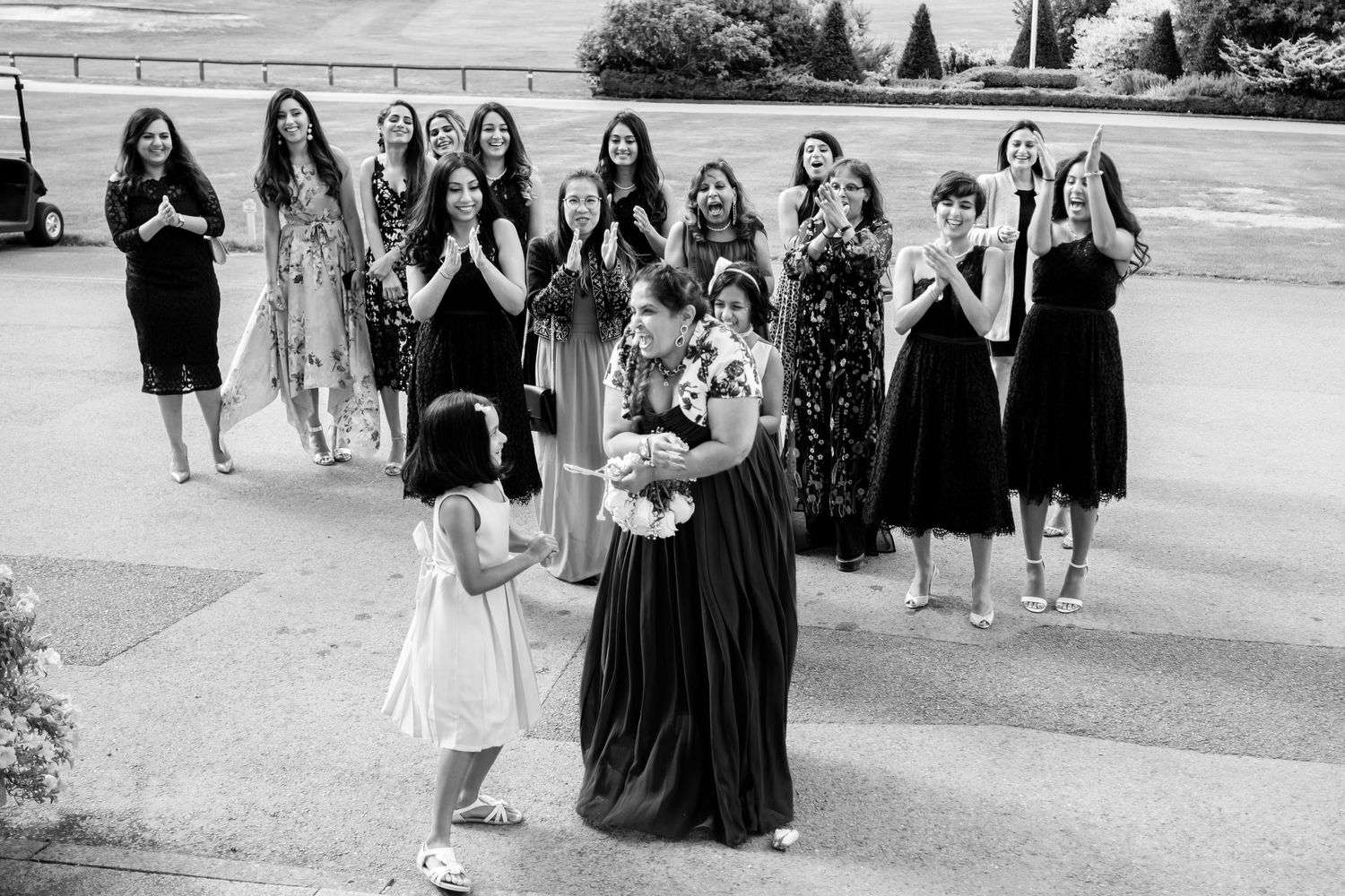 A wedding party walks together outside on a sunny day.