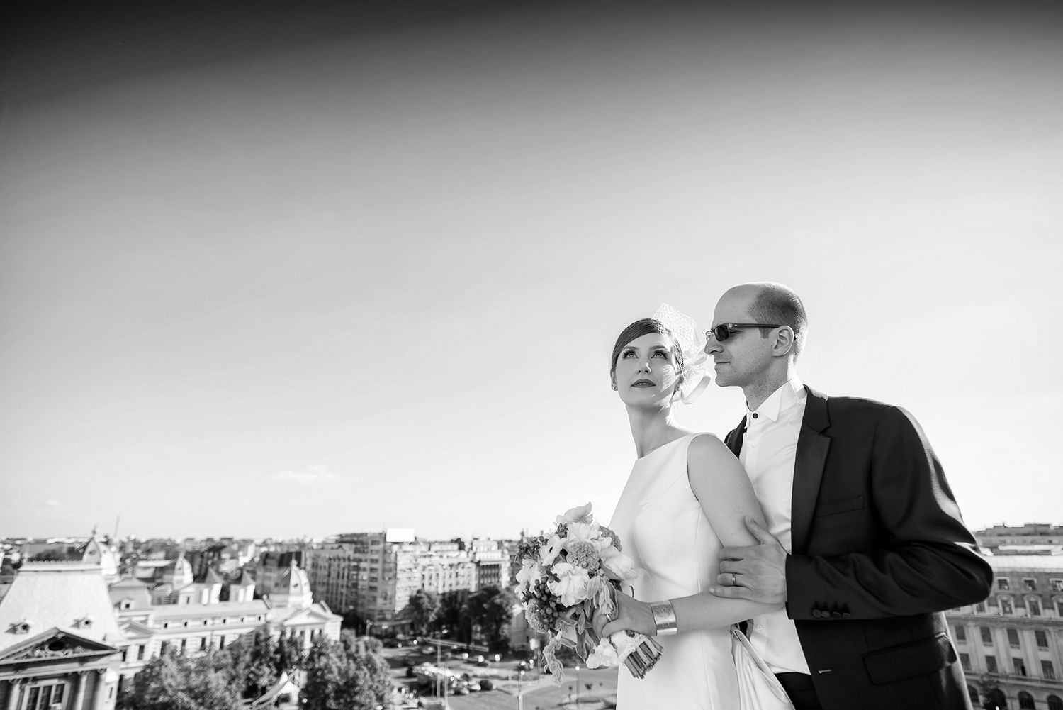 Elegant black and white wedding photography with city rooftops in the background.