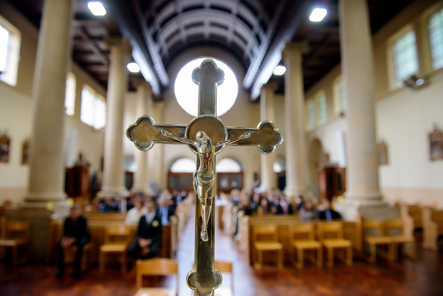 Interior of Catholic church with vaulted ceiling and crucifix for wedding ceremony.