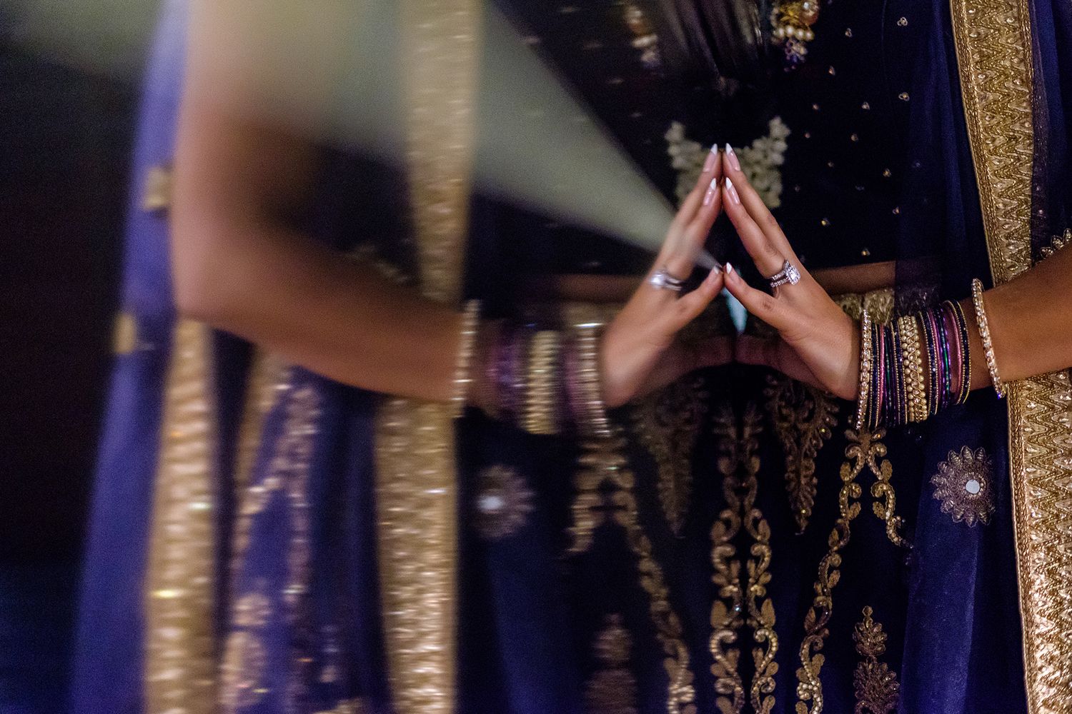 Close-up detail of traditional Indian wedding attire in deep purple and gold.