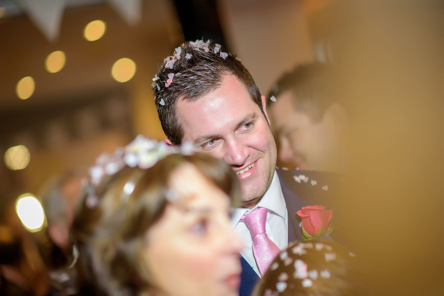 Candid scenes from a wedding reception show people dancing and celebrating in a venue with warm lighting.