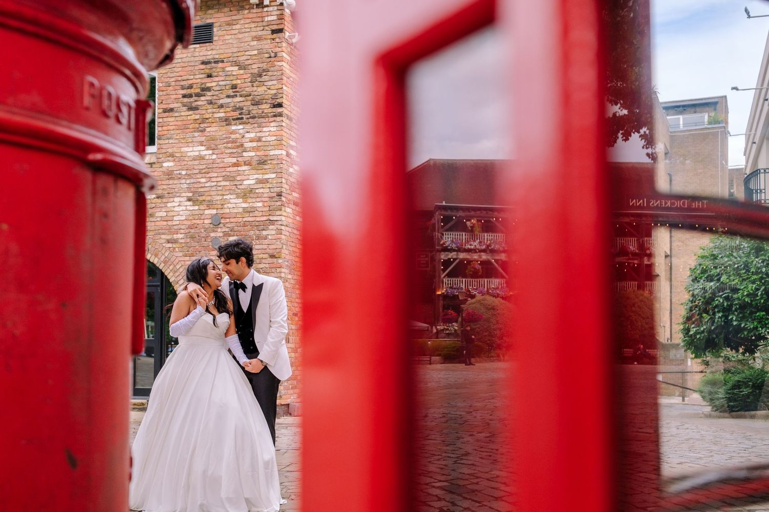 Wedding photo creatively framed between iconic red British post boxes.