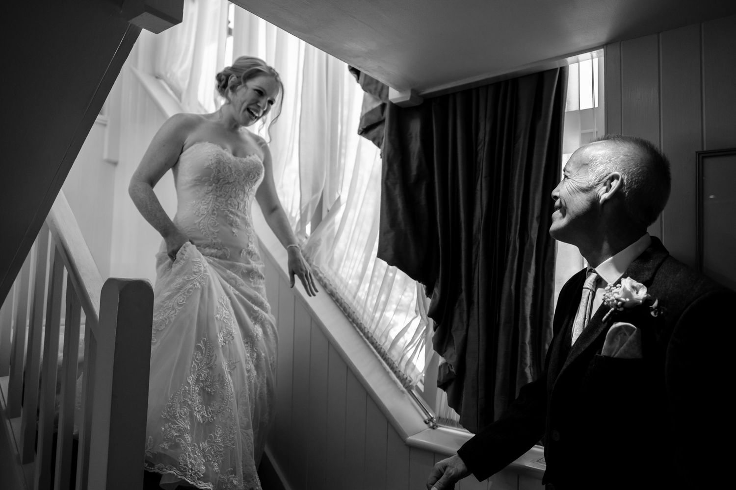 Artistic black and white shots of wedding dress preparations in natural window light.