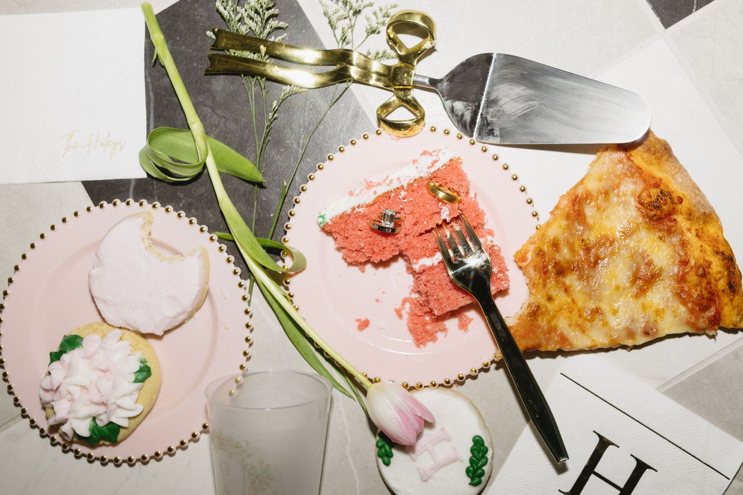 Overhead view of wedding dessert plate with pink cake slice, sugar cookie, and a slice of pizza.