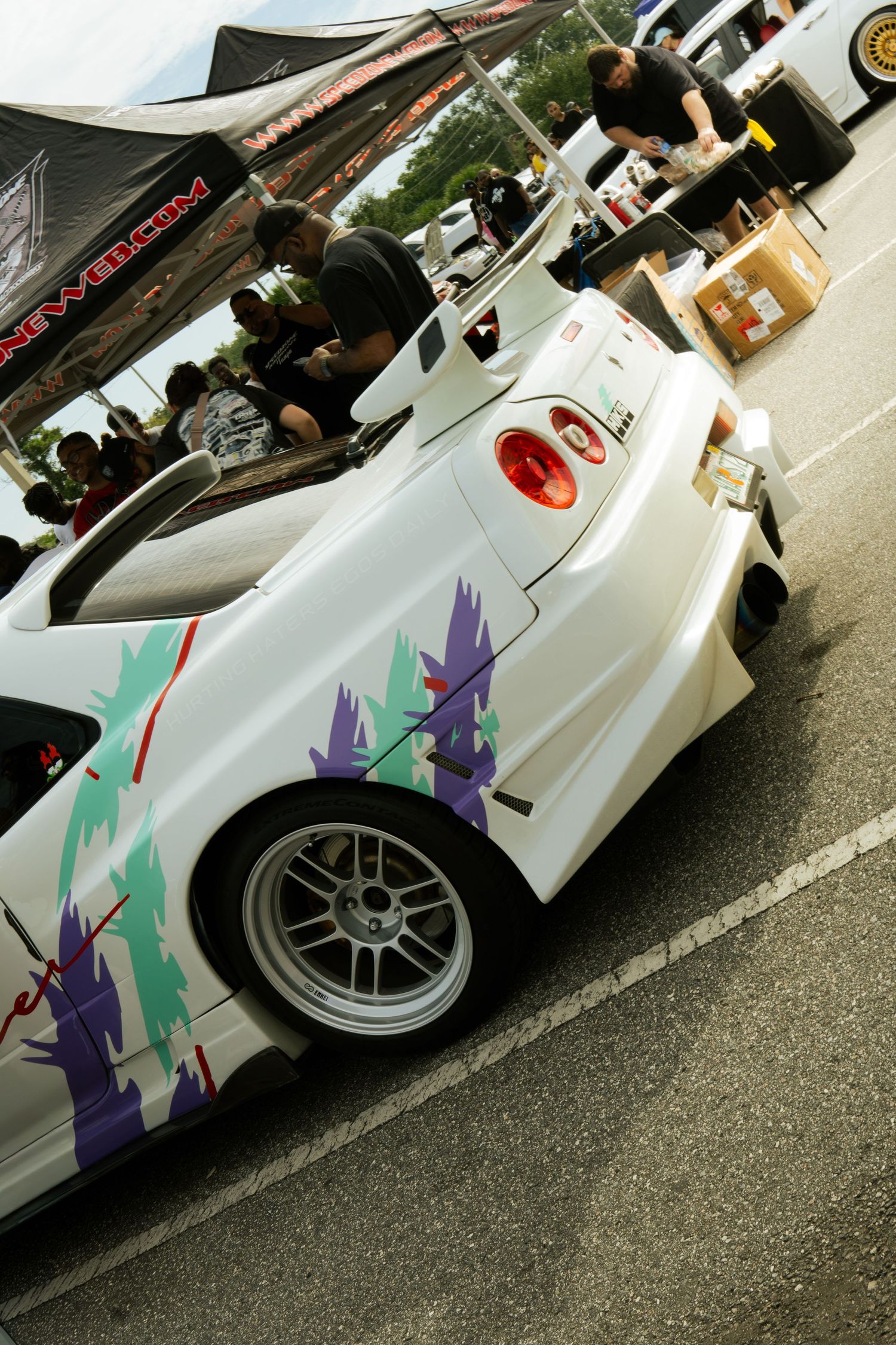 White custom Honda S2000 with colorful graphics on display at an outdoor car show.