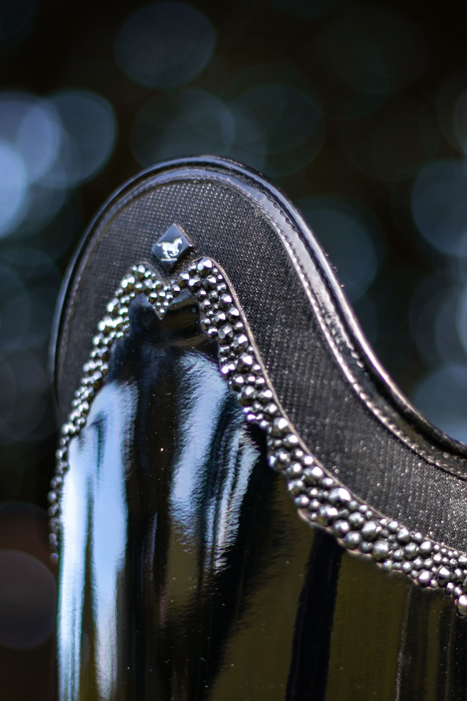 Close-up macro shot of water droplets in sequence on a dark surface with blurred background bokeh effect.