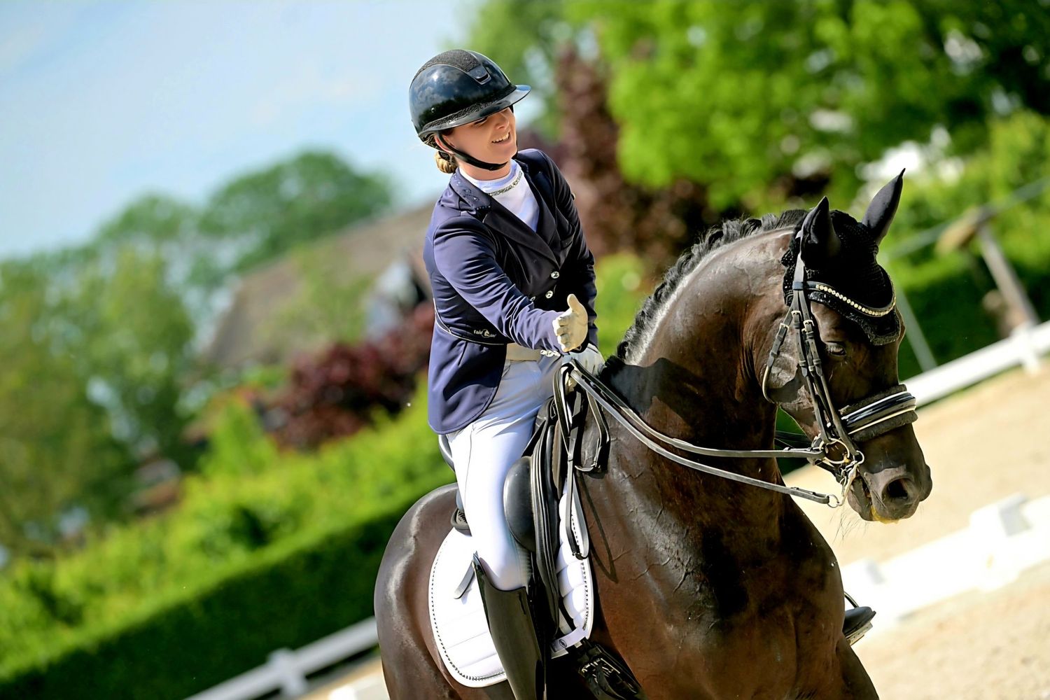 Dressage horse and rider executing precise movements in sunny outdoor arena.