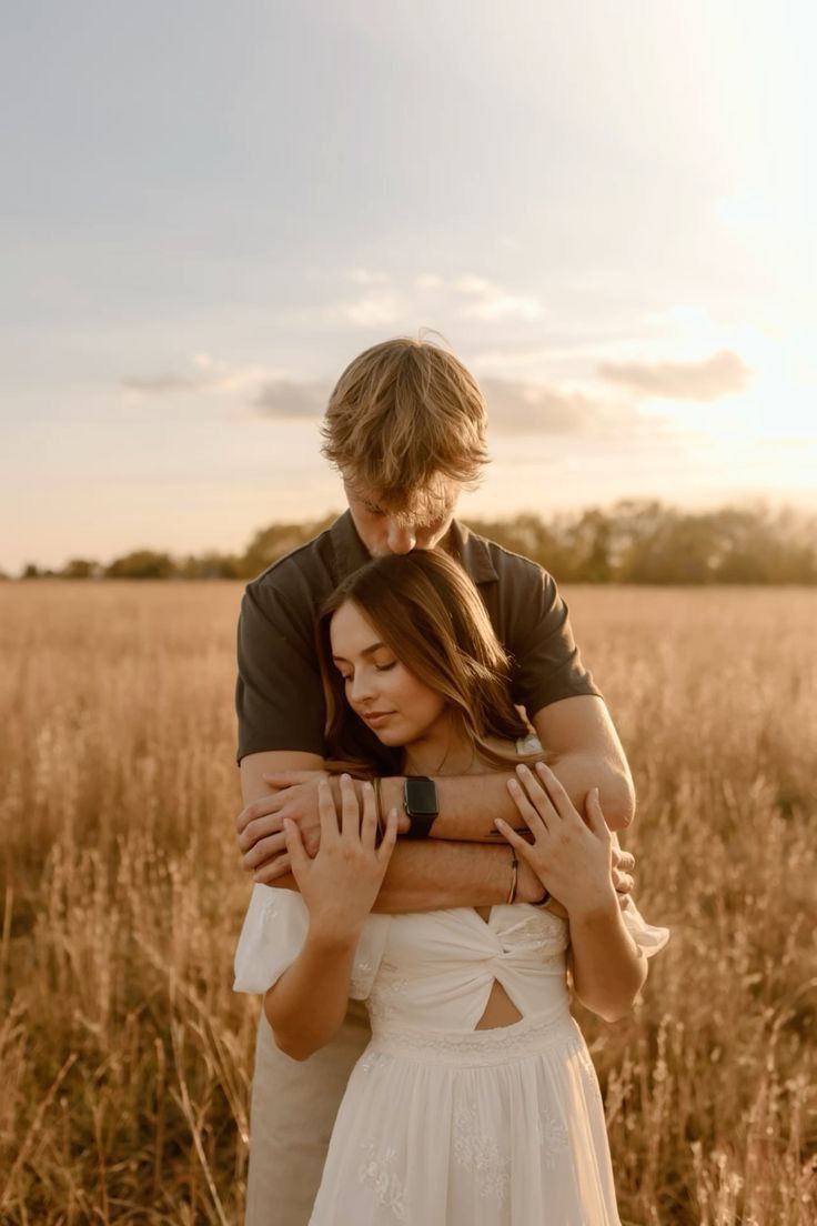 A romantic couple embraces in a golden wheat field at sunset, creating a dreamy atmospheric scene.