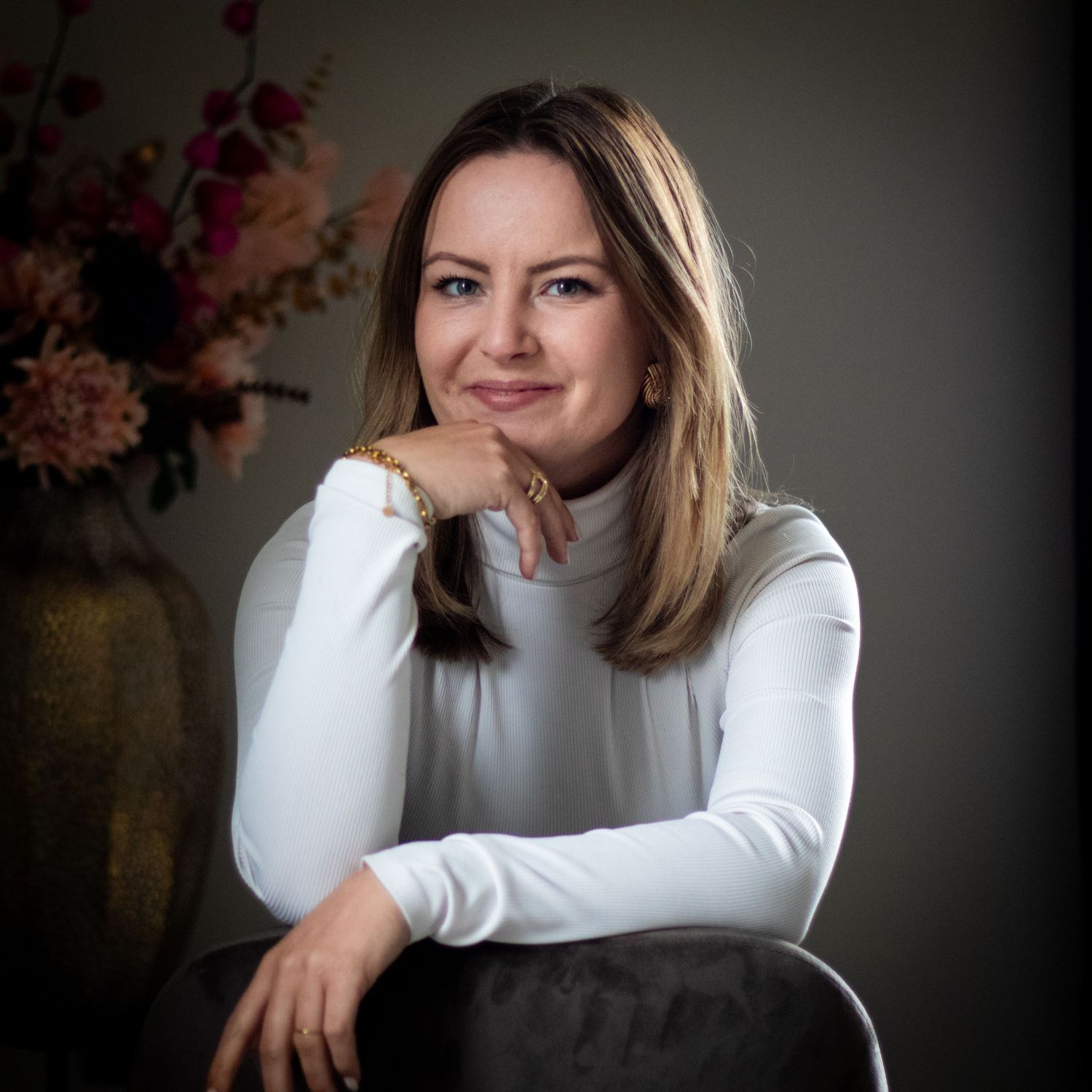 Professional portrait series showing warm expressions against a dark background in a white sweater.