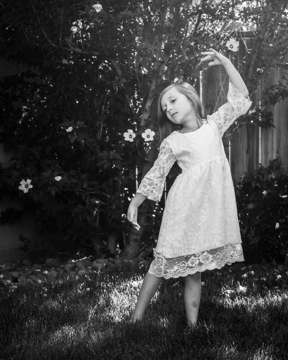 Girl dancing in the lawn with flowers strewn
