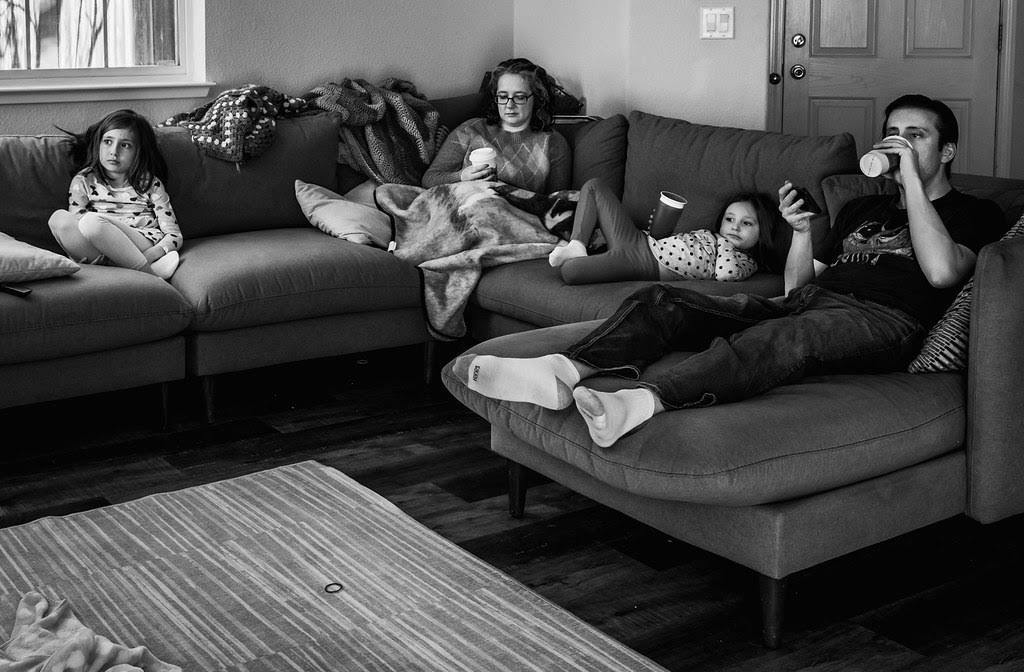 A family lounges on a couch in a living room