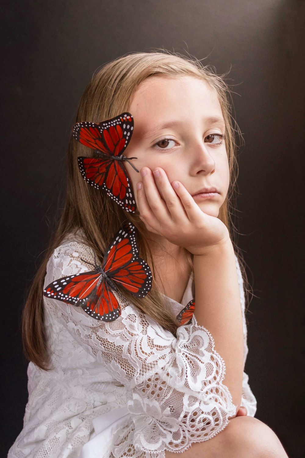 Portrait of girl with butterflies on her shoulder and face