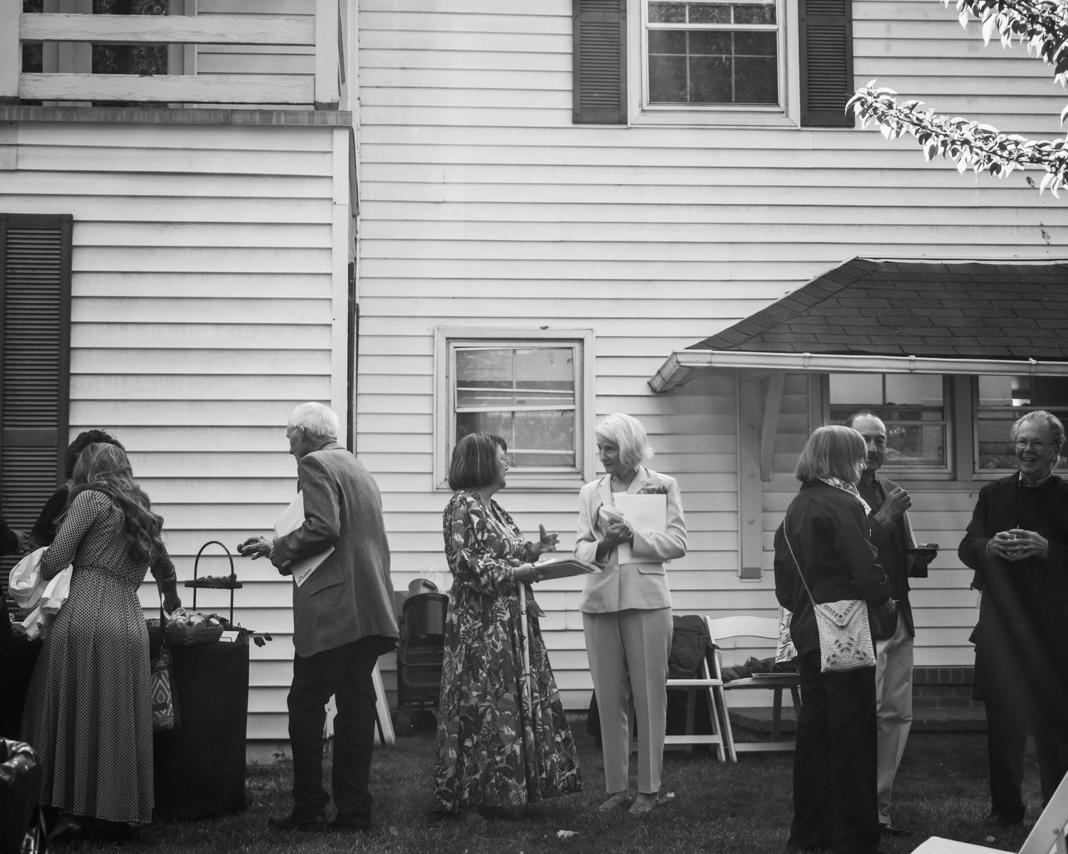 People stand and talk in front of a building