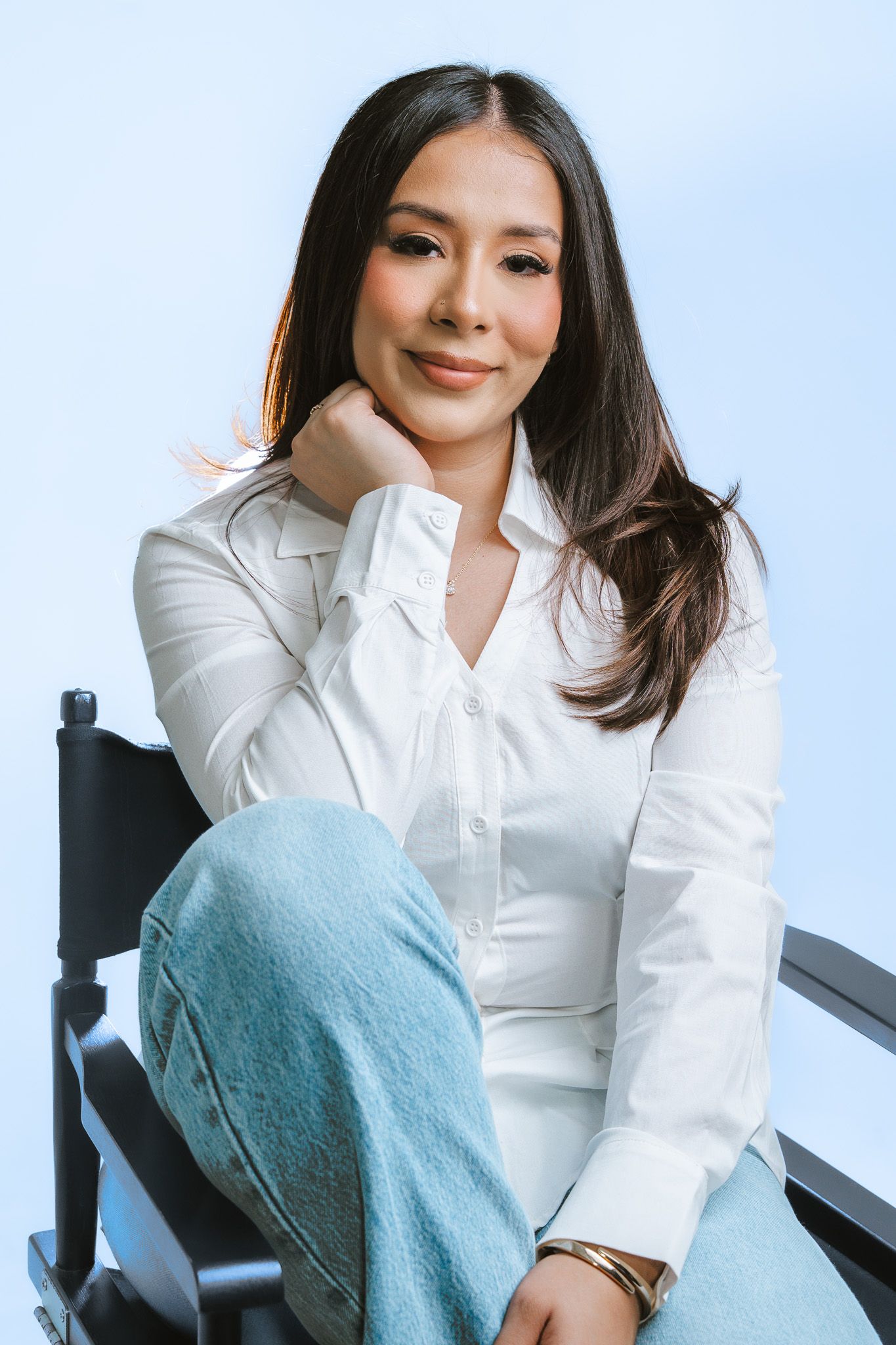 Modern business portraits in a crisp white button-down shirt against a minimalist blue backdrop.