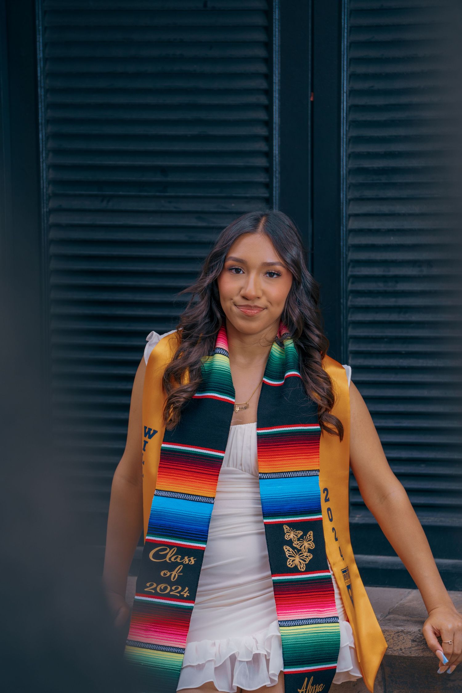 Traditional Mexican serape graduation stoles with yellow accents and embroidered details displayed indoors.