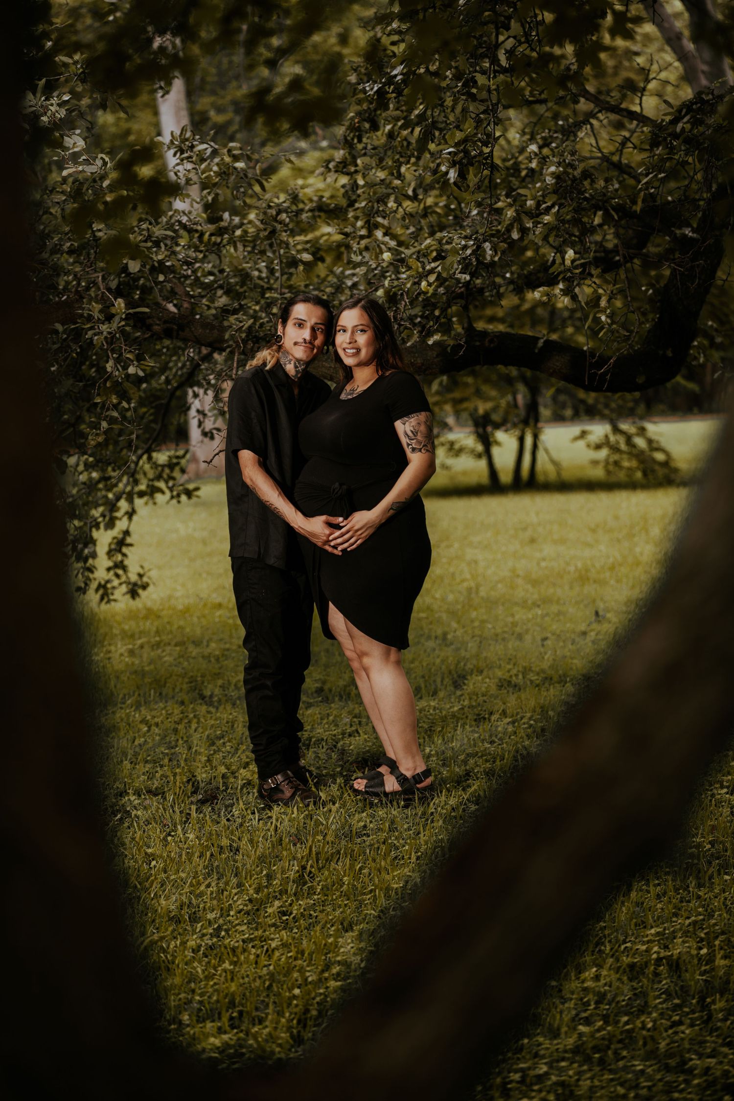 A couple shares tender moments in a sunlit garden setting.