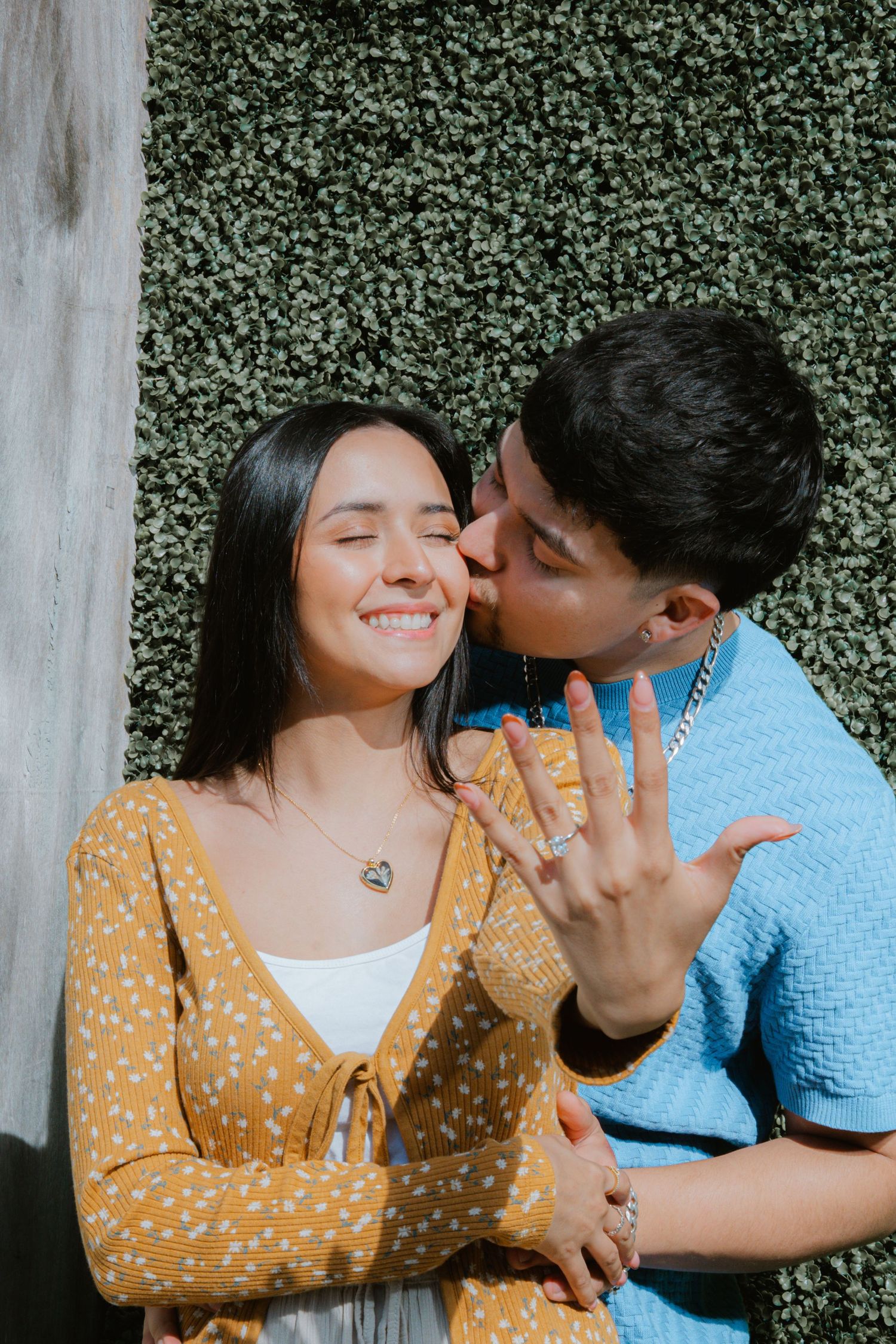 A couple shares tender moments in a series of four candid photos against a green hedge backdrop.
