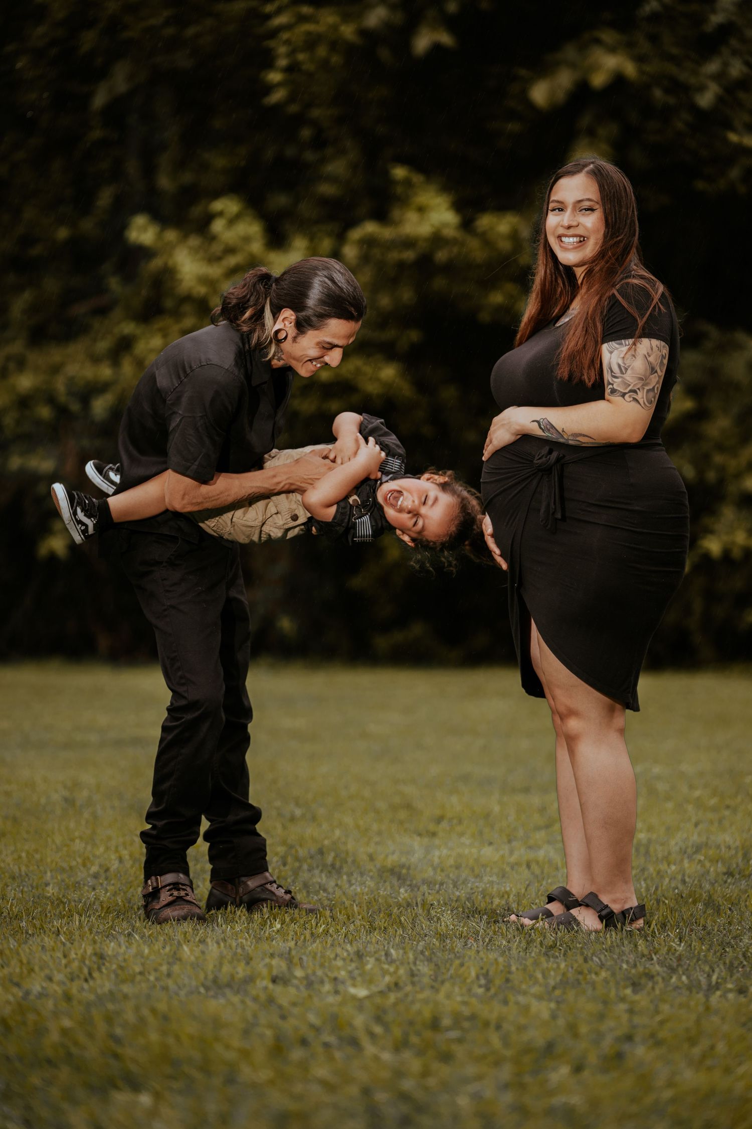 A couple shares laughter and embraces while playing in a sunny meadow.