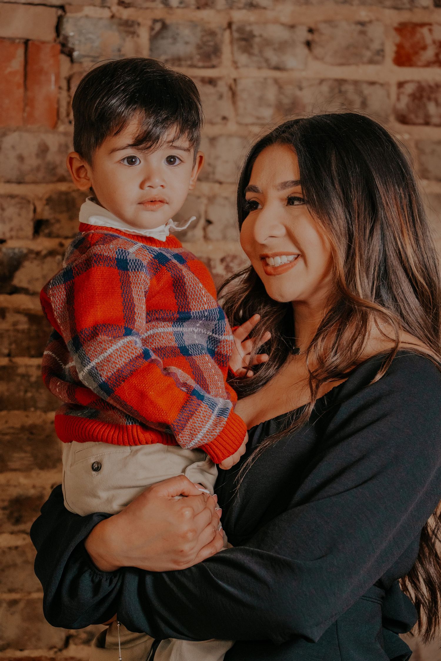 A series of warm-toned photos showing tender moments between parent and child against a rustic brick wall background.