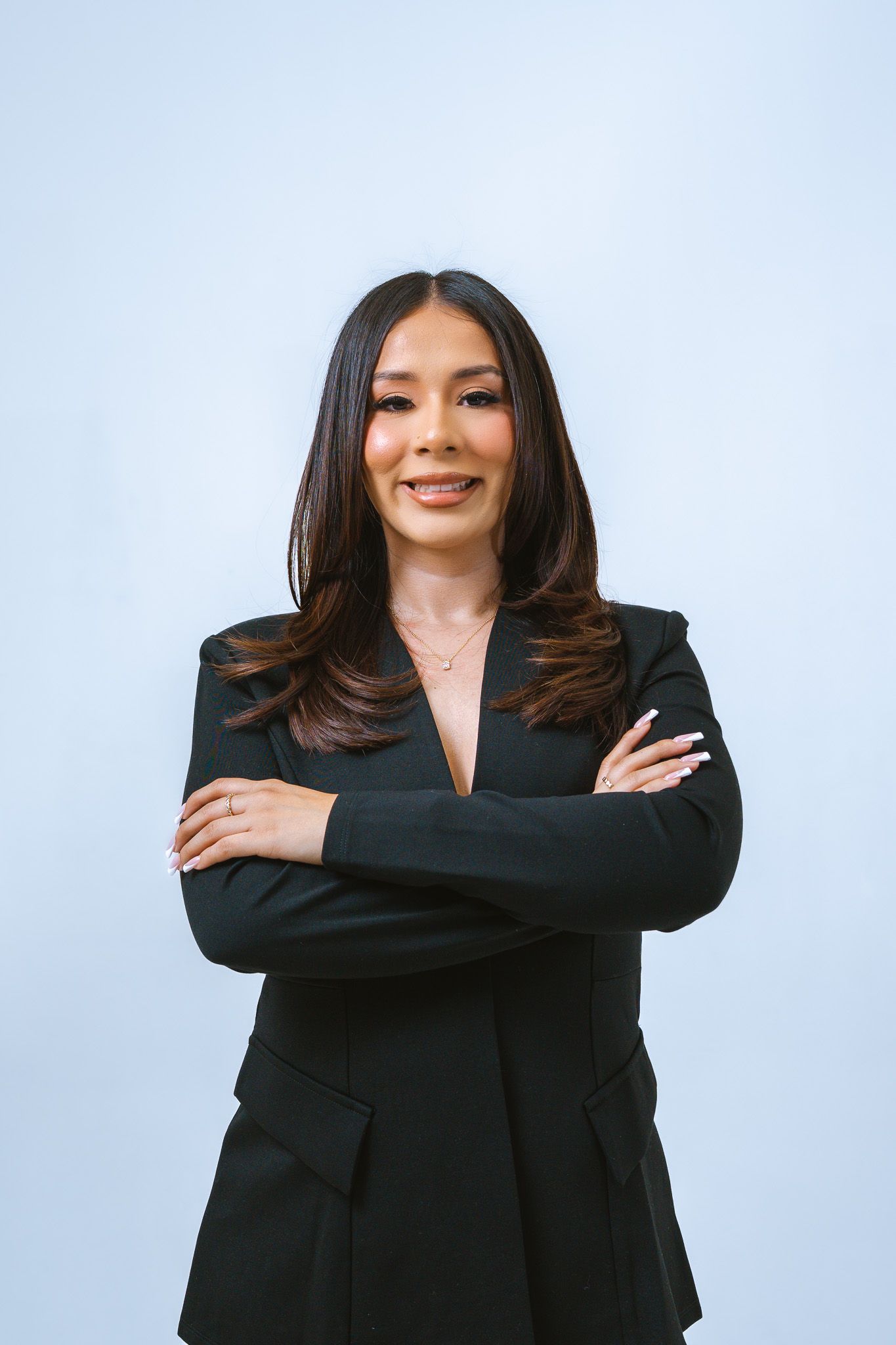 Professional business portrait of someone in a black blazer against a light blue background showing different poses.