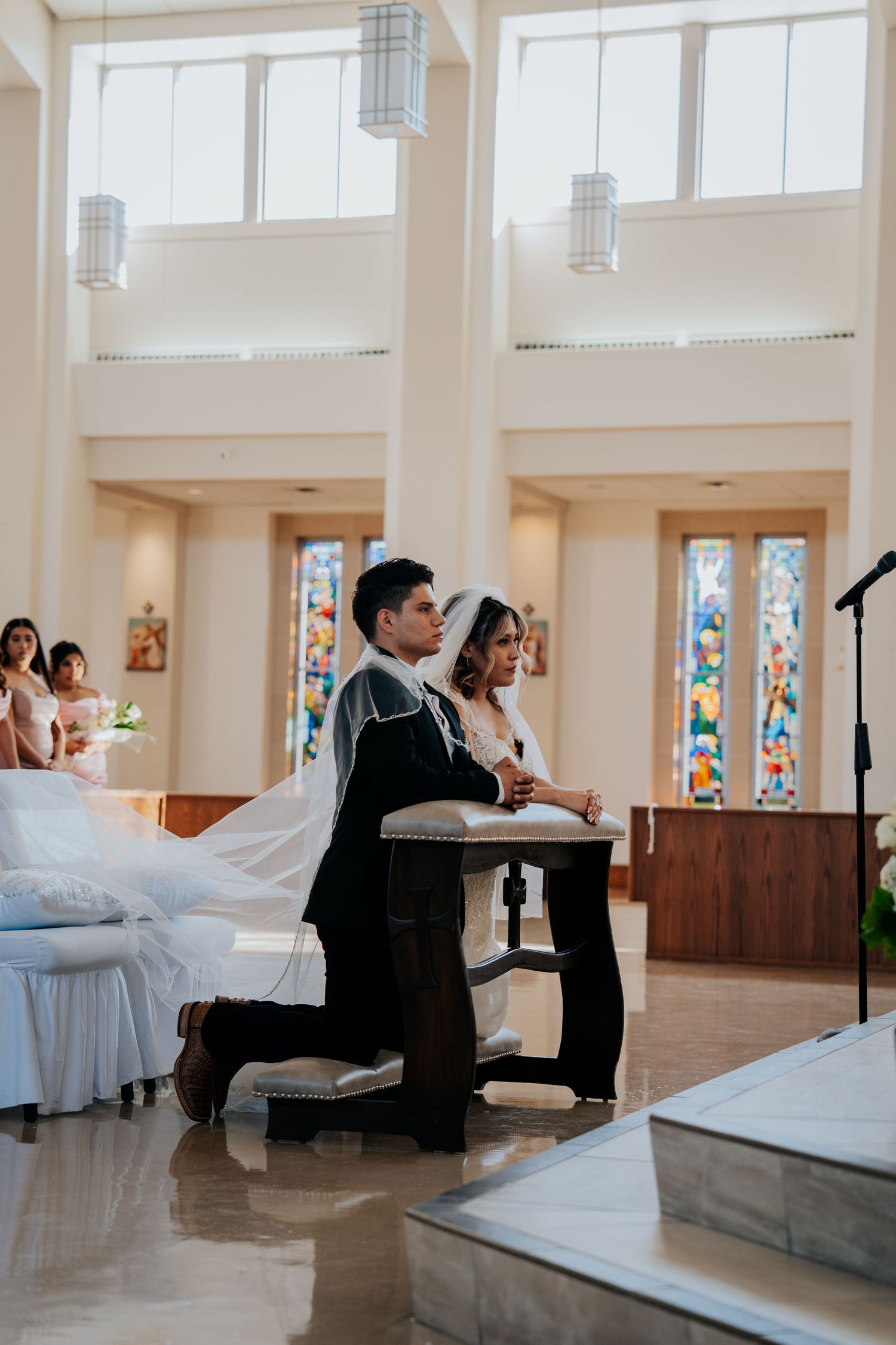 Wedding party performs choreographed dance routine in a bright church space with stained glass windows.