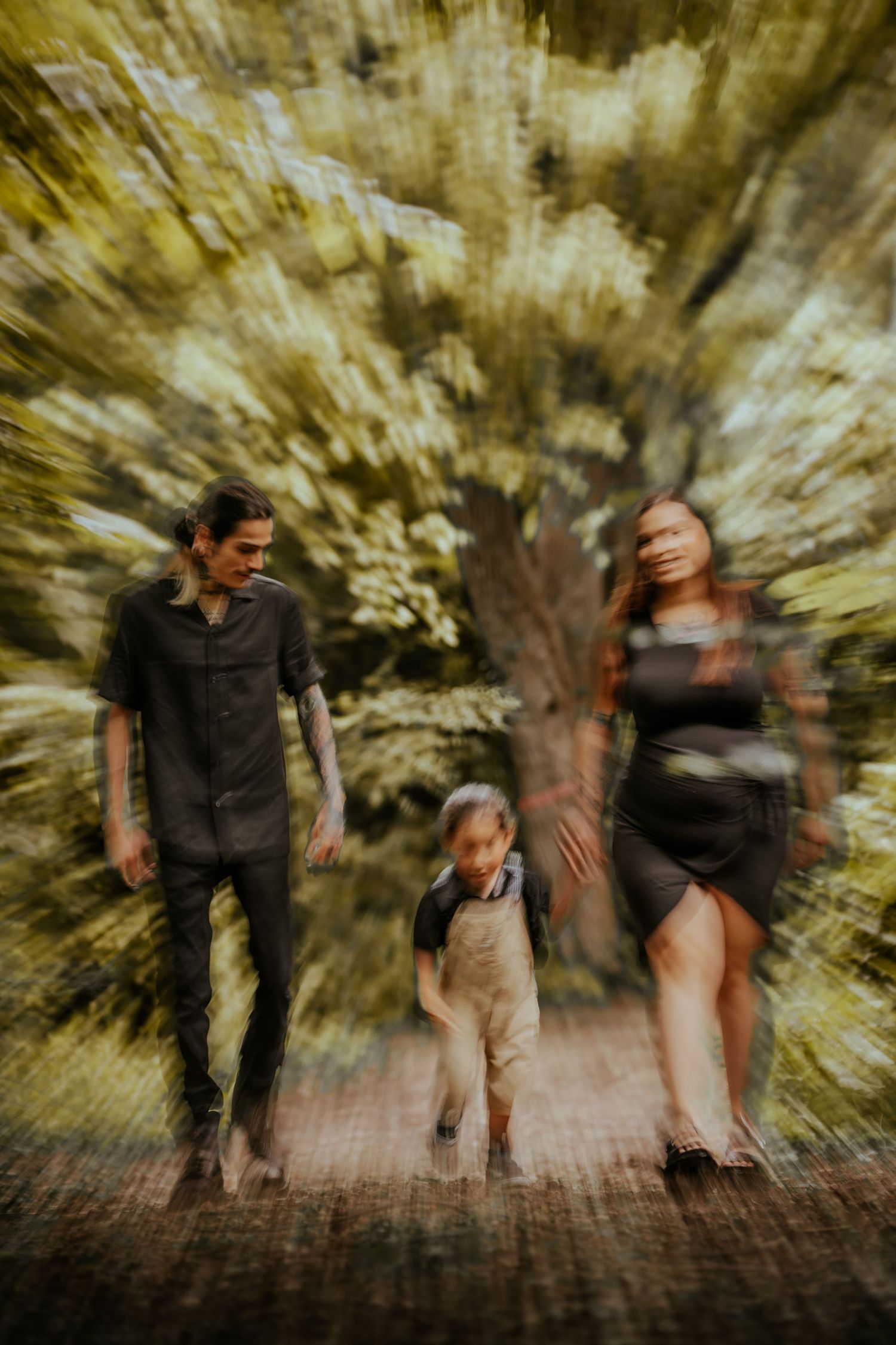 Motion blur photograph of people walking on a brick path surrounded by autumn trees creates a dynamic effect.
